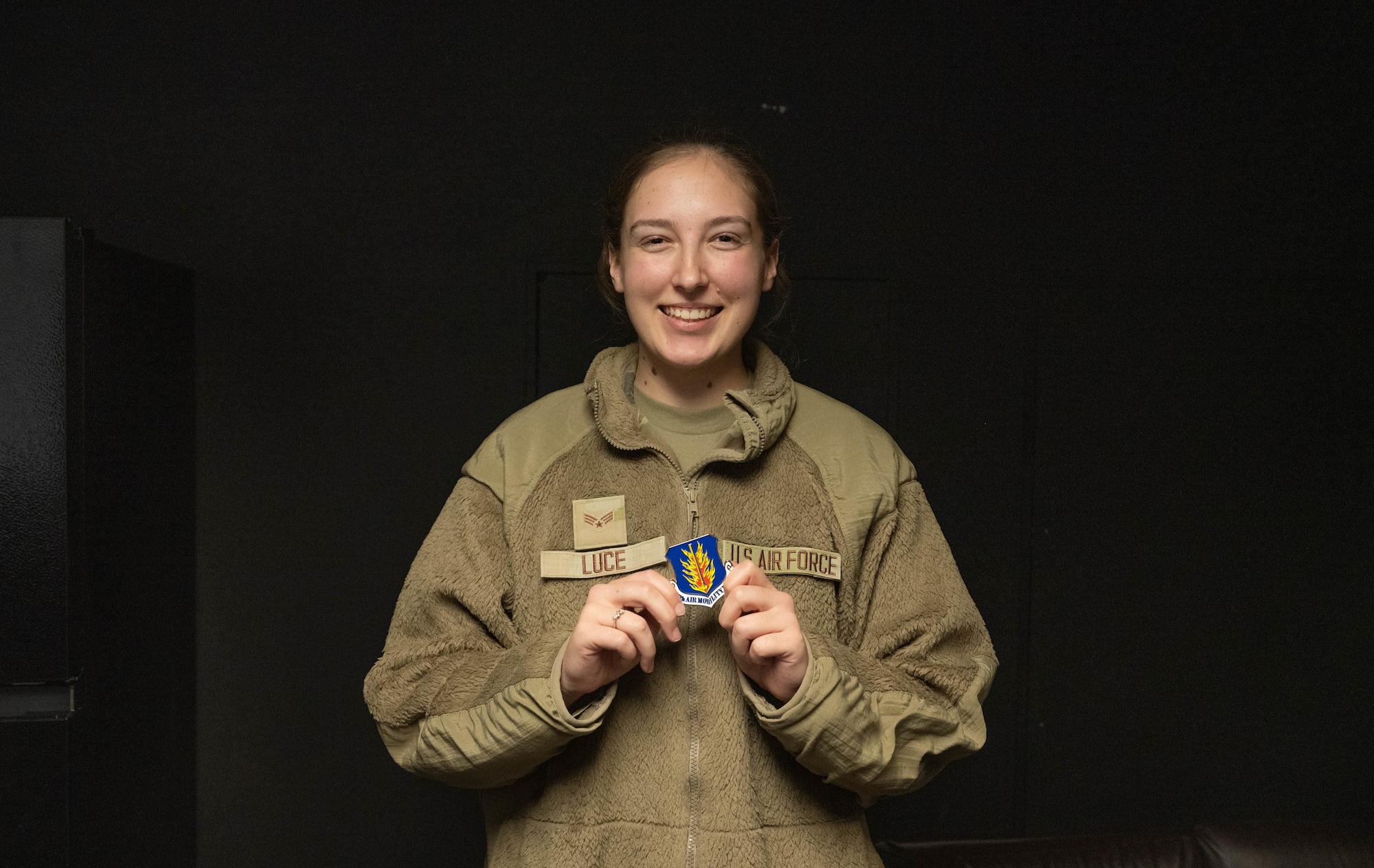 U.S. Air Force Senior Airman Sarah Luce, 97th Operations Support Squadron air traffic control trainer displays her coin at Altus Air Force Base, Oklahoma, Dec. 15, 2025. Luce was coined by U.S. Air Force Col. Richard Kind, 97th Air Mobility Wing commander, since she was named the 2025 fiscal year Air Education and Training Command Airfield Operations Trainer of the Year. (U.S. Air Force photo by Airman 1st Class Emma Wright)