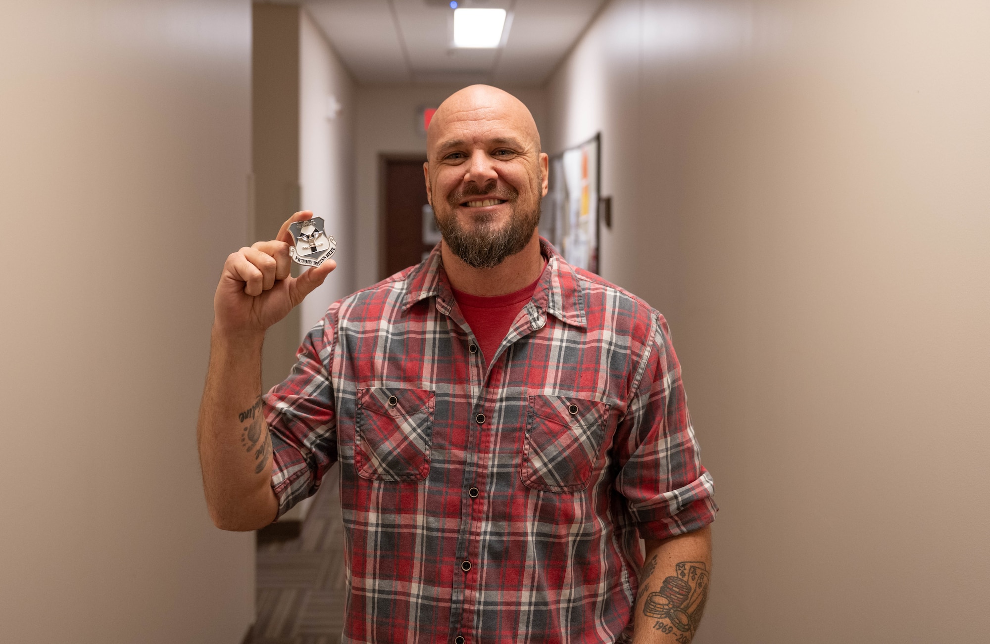 Josh Barclay, 97th Operations Support Squadron Radar, Airfield & Weather Systems lead technician displays his coin at Altus Air Force Base, Oklahoma, Dec. 16, 2025. Barclay was named the 2025 fiscal year Air Education and Training Command Airfield Operations Trainer of the Year and was coined for his outstanding performance by U.S. Air Force Col. Richard Kind, 97th Air Mobility Wing commander. (U.S. Air Force photo by Airman 1st Class Emma Wright)