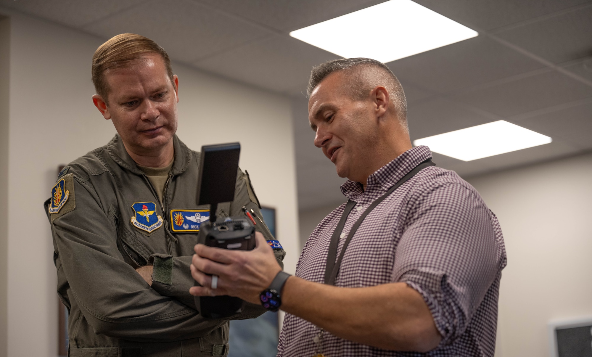U.S. Air Force Col. Richard Kind, left, 97th Air Mobility Wing commander, takes part in a War Drive Demonstration with Christopher McMall, right, 97th Communications Squadron (CS) information system security engineer, at Altus Air Force Base, Oklahoma, Dec. 18, 2025. This training exercise simulated real-world scenarios, showcasing the 97th CS’s ability to quickly establish and operationalize communication systems, cybersecurity, and networks in a new or challenging environment. (U.S. Air Force photo by Airman 1st Class Emma Wright)
