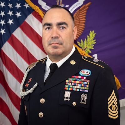 Command Sgt. Maj. Francisco Varela, Command Sgt. Maj. for the 351st Civil Affairs Command in Mountain View, CA., poses in his Army Service uniform in front of the flags of the United States of America and his Civil Affairs Command for his official command portrait.