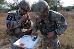 U.S. Army Staff Sgt. Michael Koenitzer, left, and Staff Sgt. Christopher Tweeddale, 232d Medical Battalion combat medic instructors, check their compass for the Land Navigation test as part of the U.S. Army Medical Center of Excellence Best Medic Competition on JBSA-Camp Bullis, Texas, Dec. 2, 2025. The competition, Dec. 1-4, 2025, seeks to demonstrate the strength, adaptability, and readiness of MEDCoE Soldiers in a variety of austere environments through a series of medical and Soldier tasks and challenges that provide appropriate rigor, resilience and realism. (U.S. Air Force photo by Melissa Hydrick)
