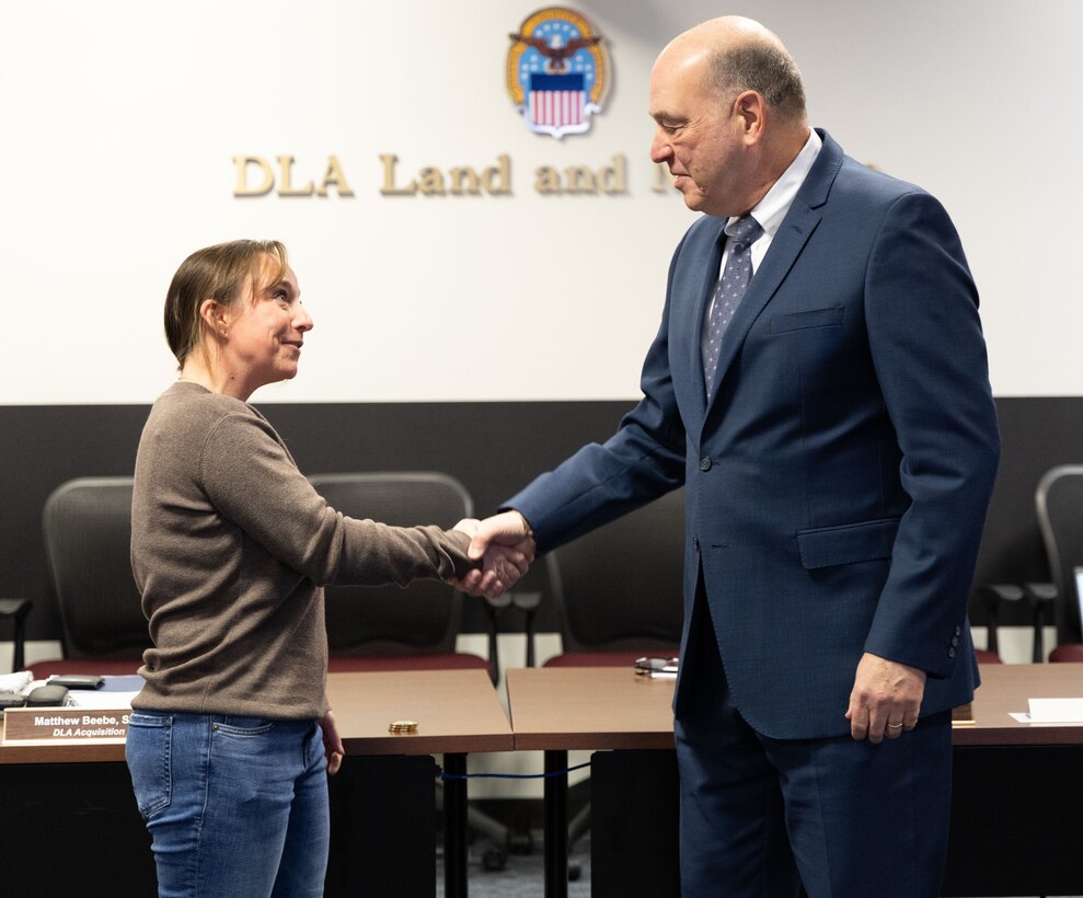 A man and a woman shake hands.