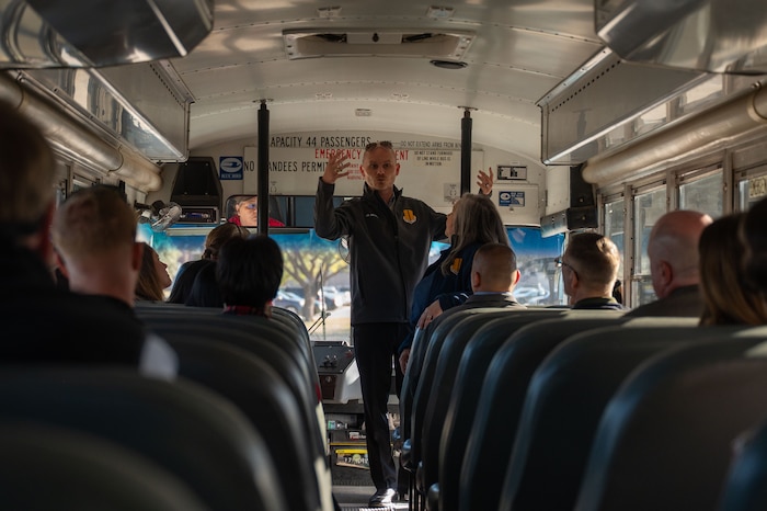 J.R. Orlando, 17th Training Wing Public Affairs chief, briefs the honorary commanders in a bus as part of a windshield tour at Goodfellow Air Force Base, Texas, Dec. 12, 2025. The tour provided insight into Goodfellow’s mission, training pipeline, and role in developing joint and coalition intelligence professionals. (U.S. Air Force photo by Airman 1st Class James Salellas)