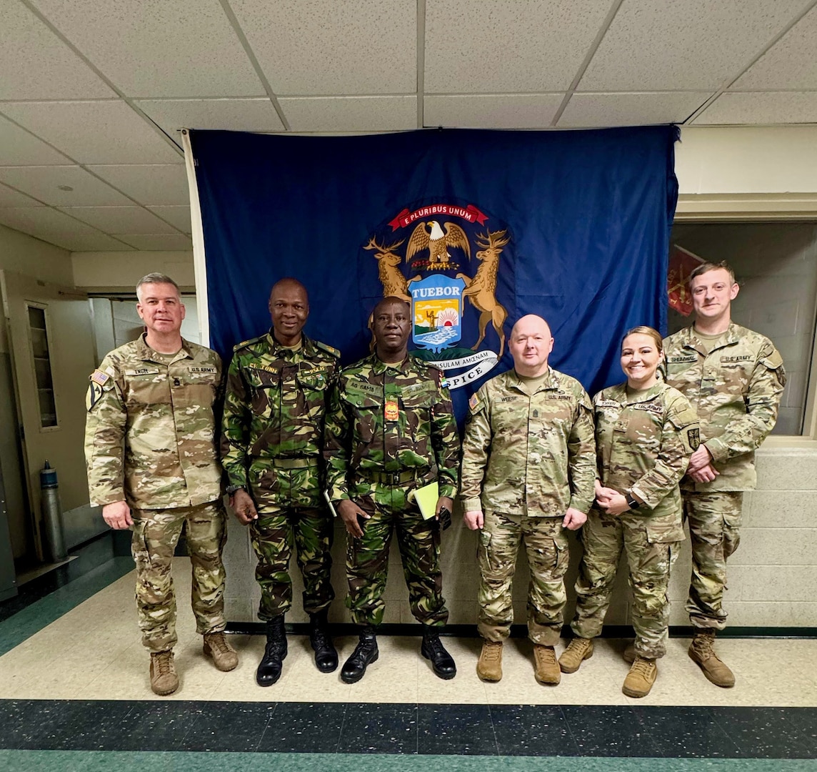 Sgt. 1st Class Michael Engel, Warrant Officer 1 Courtney Topper, Warrant Officer 1 Jacob Shumway, Warrant Officer 1 Alex G. Sama, chief of logistics for the Republic of Sierra Leone Armed Forces, and Maj. Edward K. John pose for a photo during a Department of War National Guard Bureau's State Partnership Program engagement in Michigan, December 2024.