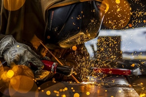 Sparks fly as a welder repairs a piece of metal.