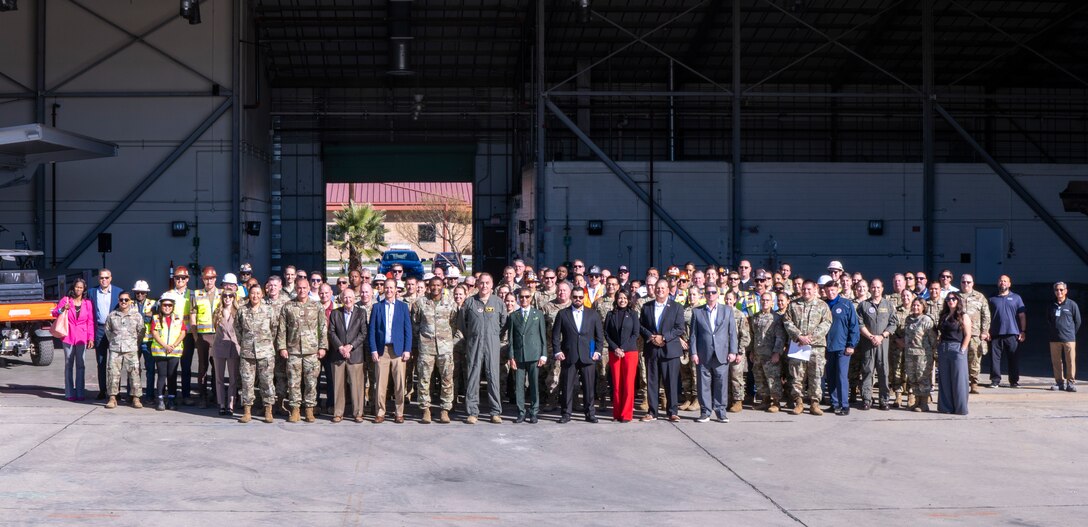 U.S. Army Corps of Engineers Los Angeles District and Air Force officials join distinguished visitors and contractors Dec. 16 for a group photo in front of a hangar scheduled for demolition to make way for construction on a new KC-46 Pegasus hangar and training facility at March Air Reserve Base in Riverside County, California.