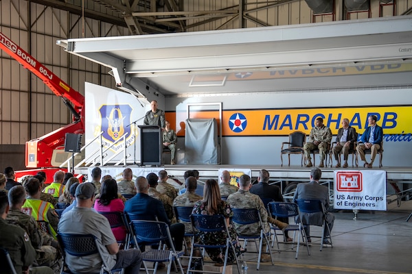 U.S. Air Force Col. Bryan Bailey, commander of the 452nd Air Mobility Wing, on stage at left, addresses attendees during a groundbreaking ceremony for a new KC-46 Pegasus hangar and training facility Dec. 16 at March Air Reserve Base in Riverside County, California.
