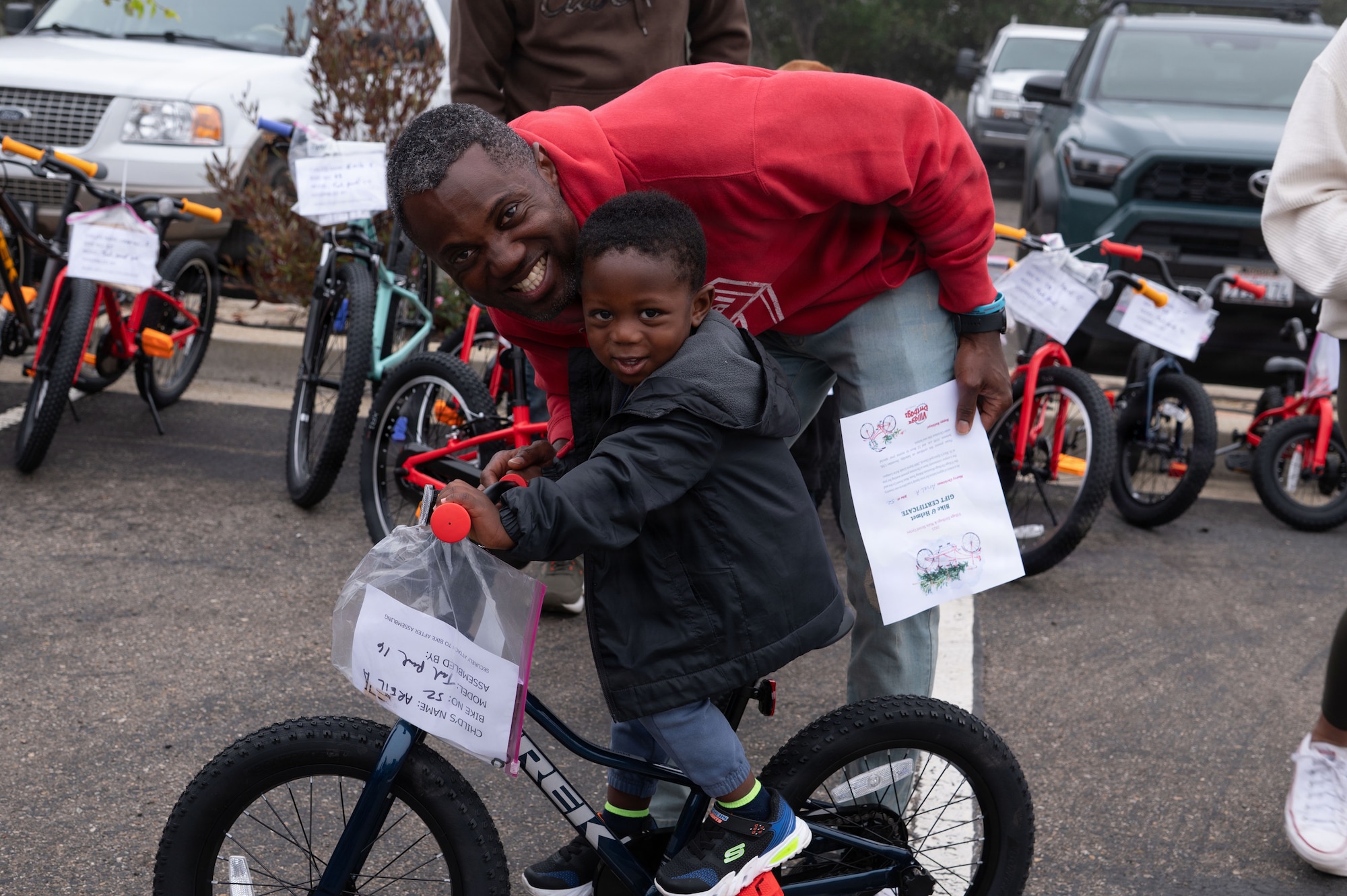 a man and a child on a bike smile for a photo