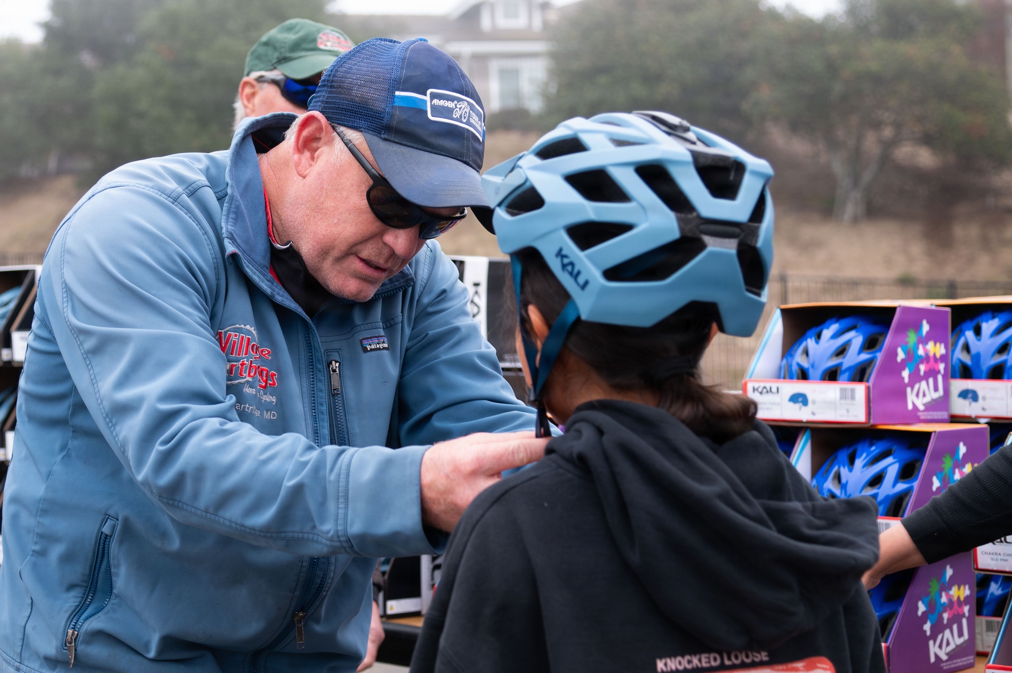 a person straps a helmet onto a young kid