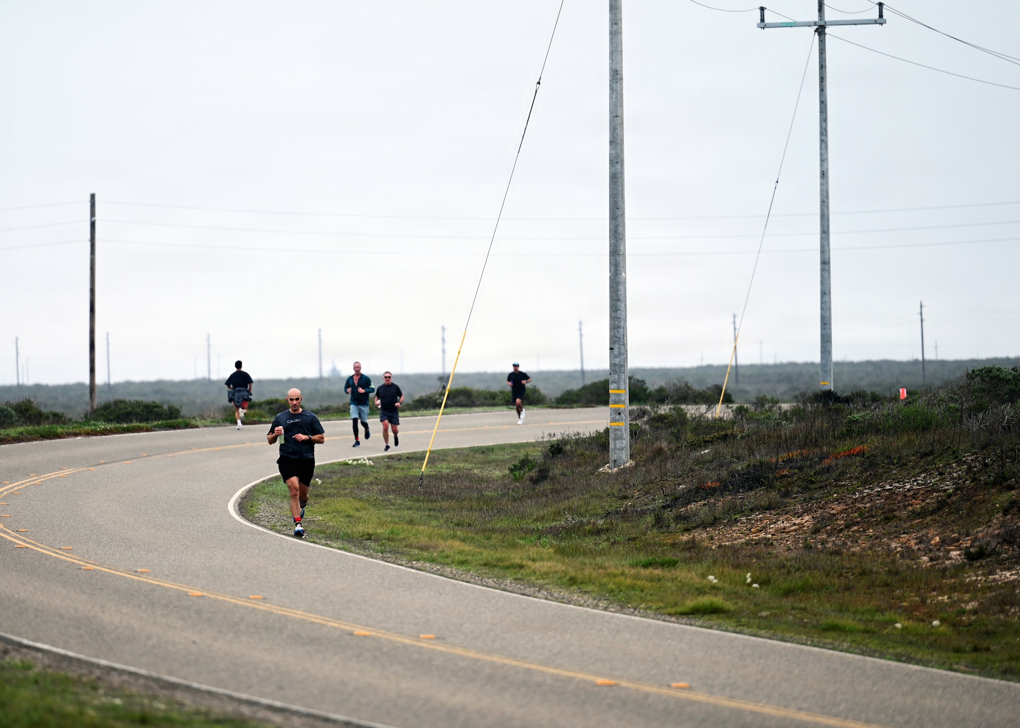 Participants runs on the side of the road