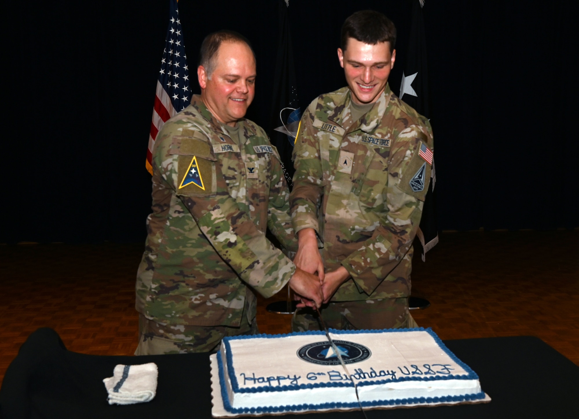 The highest and lowest ranking members at the USSF birthday celebration join to make the first cut of the ceremonial cake.
