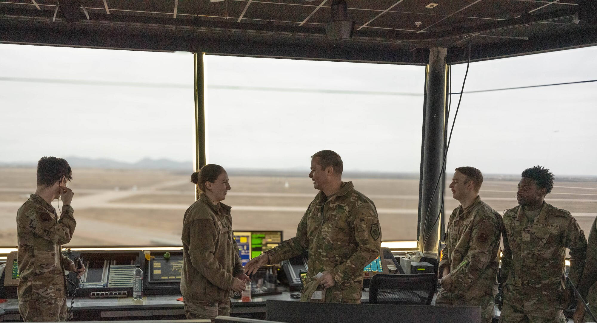 U.S. Air Force Col. Richard Kind, 97th Air Mobility Wing commander, coins U.S. Air Force Senior Airman Sarah Luce, 97th Operations Support Squadron air traffic control trainer, at Altus Air Force Base, Oklahoma, Dec. 15, 2025. Luce was recognized as the 2025 fiscal year Air Education and Training Command Airfield Operations Trainer of the Year, rewarding her exceptional performance and commitment to her duties. (U.S. Air Force photo by Airman 1st Class Emma Wright) 
This photo was altered for security purposes by blurring out flight monitors.
