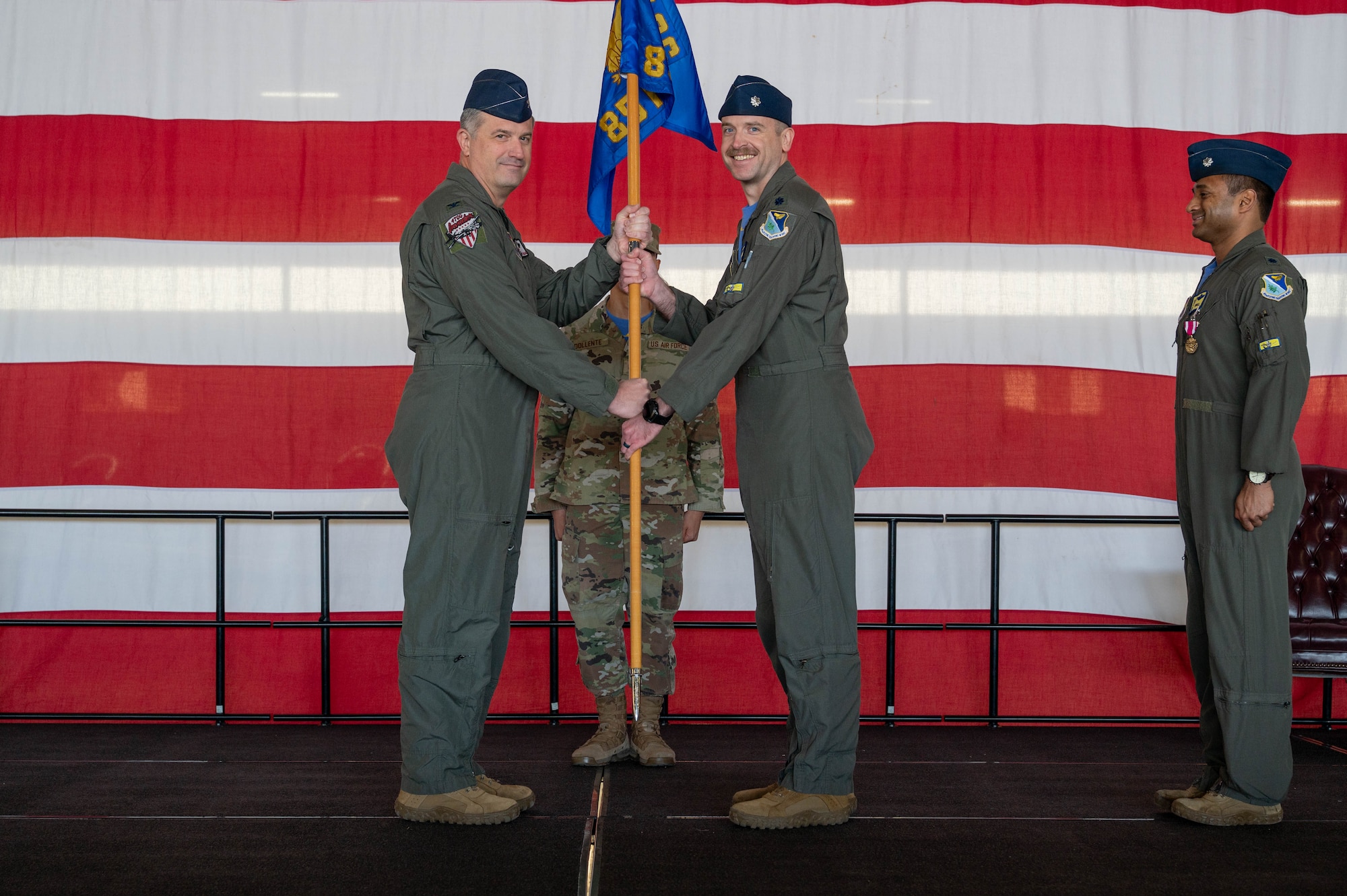 Service members pass squadron guidon.