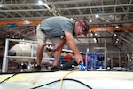 Brent Griffin, a sheet metal mechanic assigned to the 559th Aircraft Maintenance Squadron, vacuums debris out of a C-5M Super Galaxy aircraft horizontal stabilizer at the Warner Robins Air Logistics Complex at Robins Air Force Base, Ga., May 29, 2025.