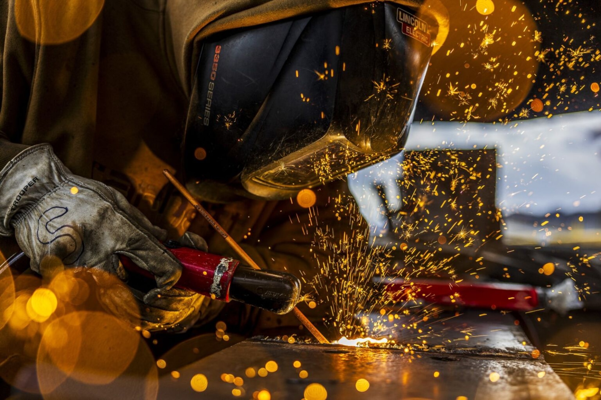 Sparks fly as a welder repairs a piece of metal.