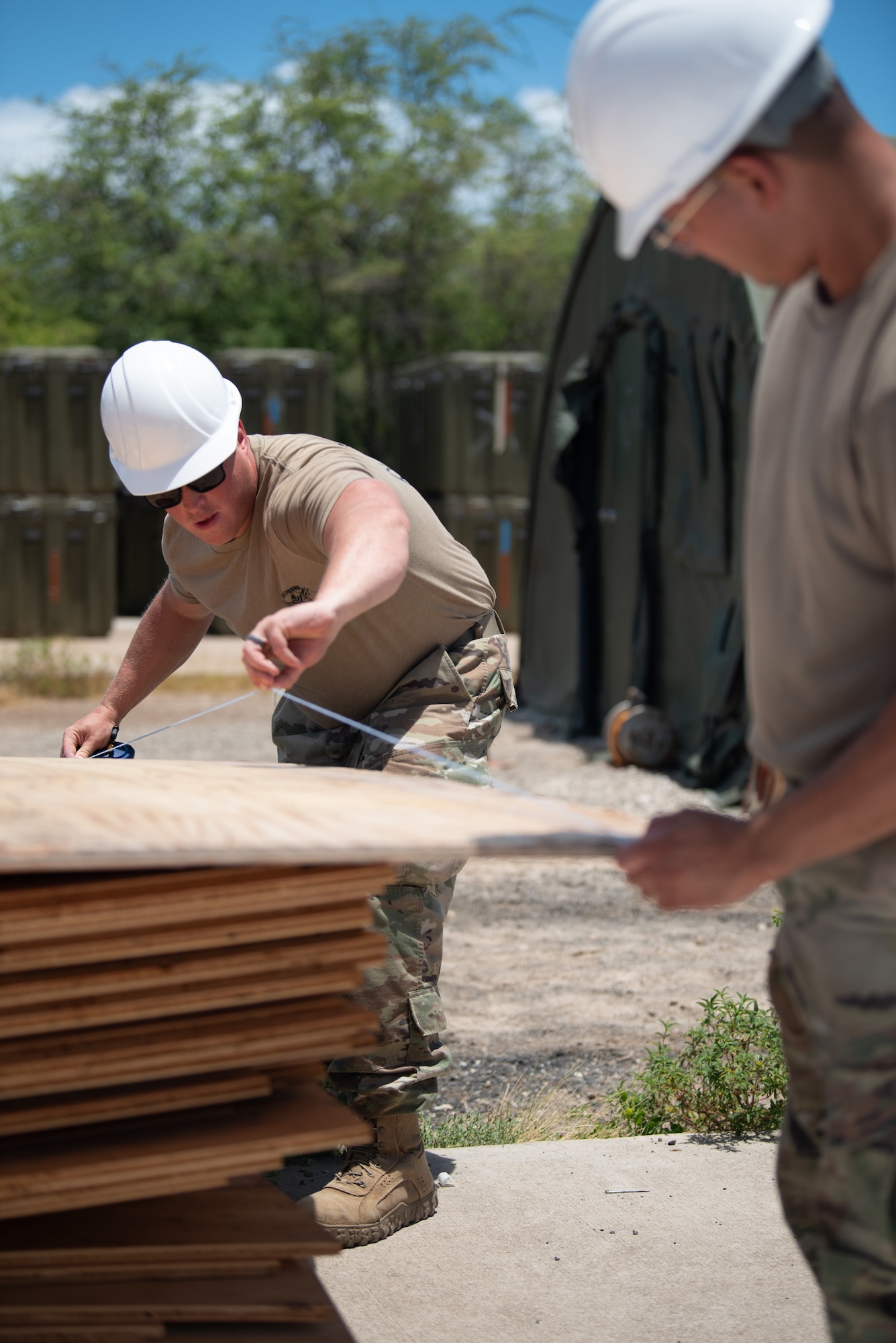 Staff Sgt. Nicholas Reed, left, and Senior Airman Elmer Lopez-Duran, structural specialists with the Kentucky Air National Guard’s 123rd Civil Engineer Squadron, lay down a cutting line during the construction of a joint operations center at Joint Base Pearl Harbor-Hickam, Hawaii, on July 29, 2025. The Kentucky Guard troops were among more than 70 personnel from the Louisville-based 123rd Airlift Wing to conduct annual training here over 14 days, working with their counterparts from the active duty to enhance expeditionary skills and mission capabilities. (U.S. Air National Guard photo by Phil Speck)