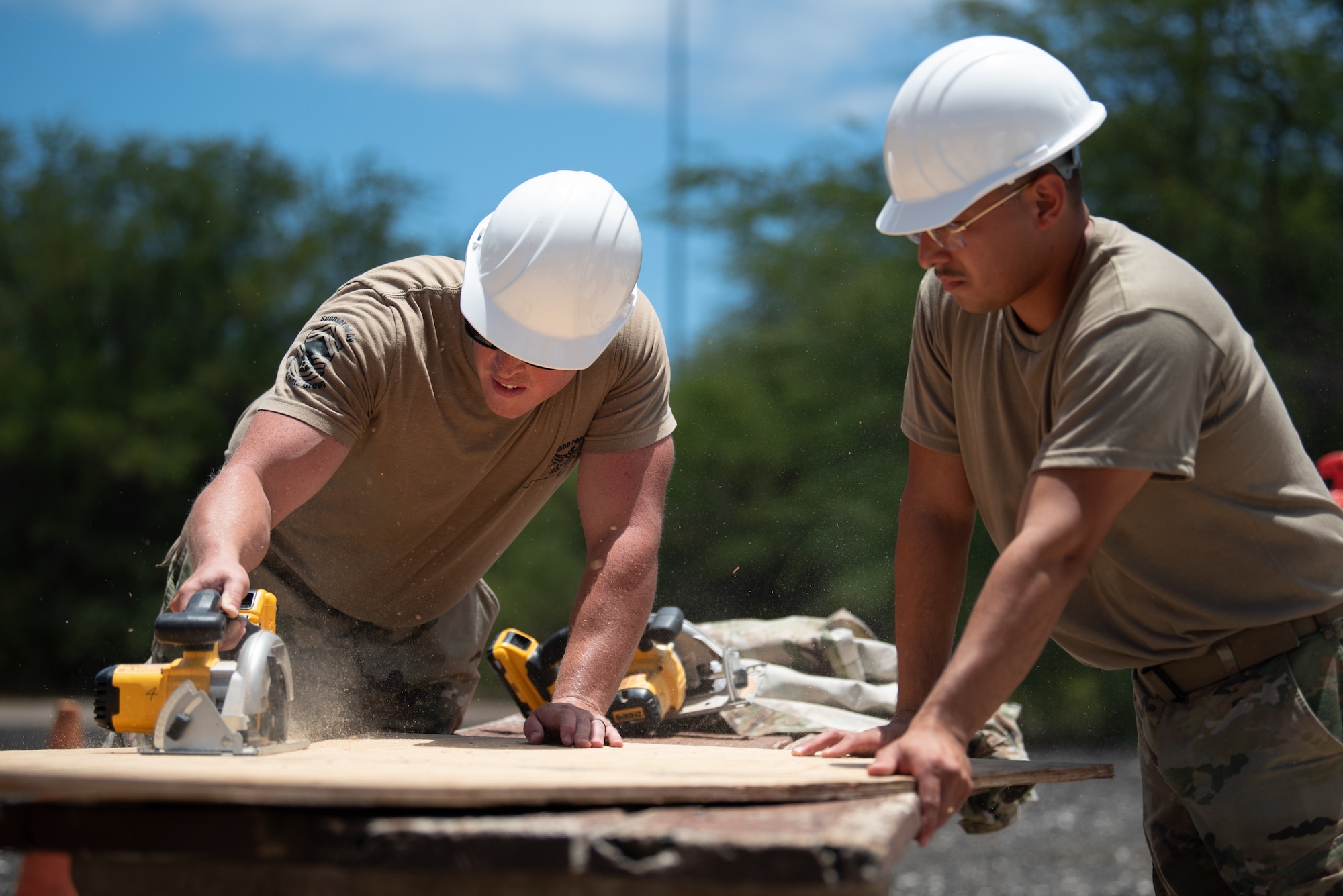 Staff Sgt. Nicholas Reed, left, and Senior Airman Elmer Lopez-Duran, structural specialists with the Kentucky Air National Guard’s 123rd Civil Engineer Squadron, cut plywood for the construct a joint operations center at Joint Base Pearl Harbor-Hickam, Hawaii, on July 29, 2025. The Kentucky Guard troops were among more than 70 personnel from the Louisville-based 123rd Airlift Wing to conduct annual training here over 14 days, honing skills that enhance their employment as Multi-Capable Airmen. (U.S. Air National Guard photo by Phil Speck)