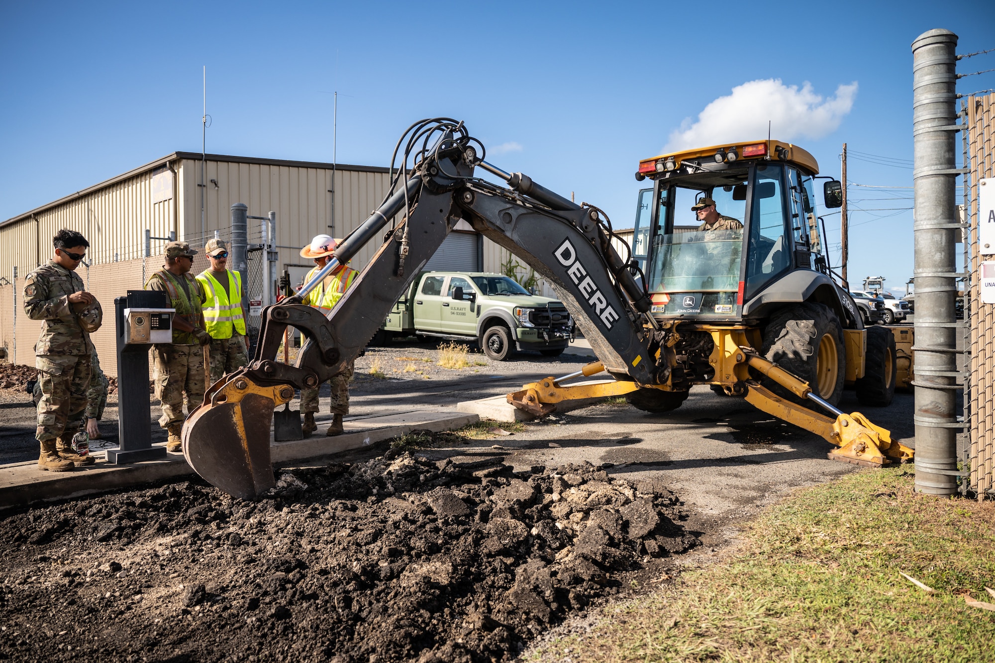 Tech. Sgt. Patrick Lawrence, right, a construction specialist from the Kentucky Air National Guard’s 123rd Civil Engineer Squadron, operates a backhoe to repair pavement at Joint Base Pearl Harbor-Hickam, Hawaii, with help from his active-duty counterparts at the 647th Civil Engineer Squadron on July 29, 2025. Lawrence is among more than 70 Airmen from the Louisville-based 123rd Airlift Wing to conduct annual training here over 14 days, sharpening skills that enhance their global employment as Multi-Capable Airmen. (U.S. Air National Guard photo by Dale Greer)
