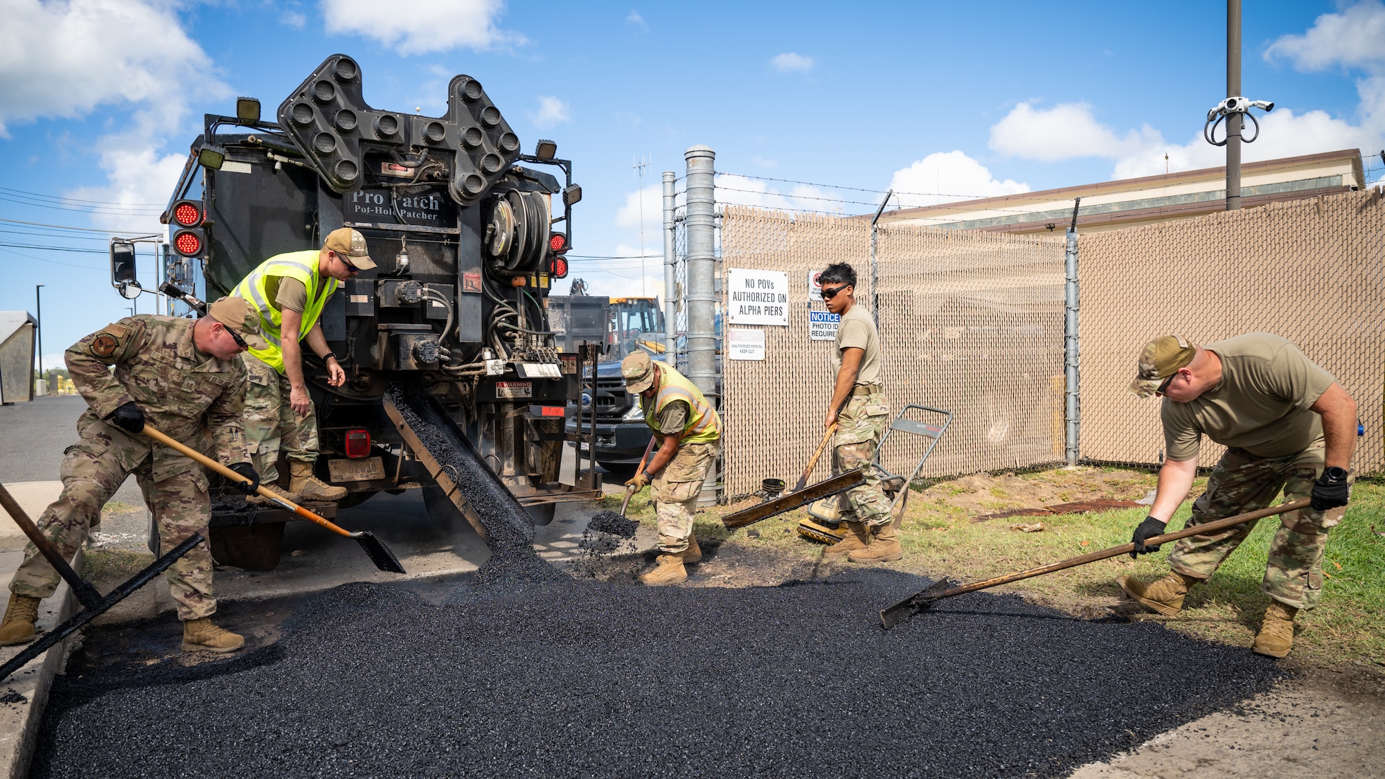 Tech. Sgt. Patrick Lawrence, left, and Tech. Sgt. Jason Rutherford, right, both construction specialists from the Kentucky Air National Guard’s 123rd Civil Engineer Squadron, work with their active-duty counterparts from the 647th Civil Engineer Squadron to replace asphalt pavement at Joint Base Pearl Harbor-Hickam, Hawaii, on July 29, 2025. The Kentucky troops are among more than 70 personnel from the Louisville-based 123rd Airlift Wing to conduct annual training here over 14 days, sharpening skills that enhance their global employment as Multi-Capable Airmen. (U.S. Air National Guard photo by Dale Greer)