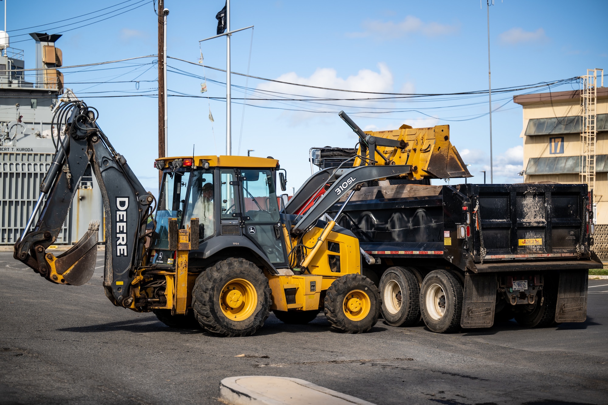 Tech. Sgt. Patrick Lawrence, a construction specialist from the Kentucky Air National Guard’s 123rd Civil Engineer Squadron, operates a backhoe to repair pavement at Joint Base Pearl Harbor-Hickam, Hawaii, with help from his active-duty counterparts at the 647th Civil Engineer Squadron on July 29, 2025. Lawrence is among more than 70 Airmen from the Louisville-based 123rd Airlift Wing to conduct annual training here over 14 days, sharpening skills that enhance their global employment as Multi-Capable Airmen. (U.S. Air National Guard photo by Dale Greer)