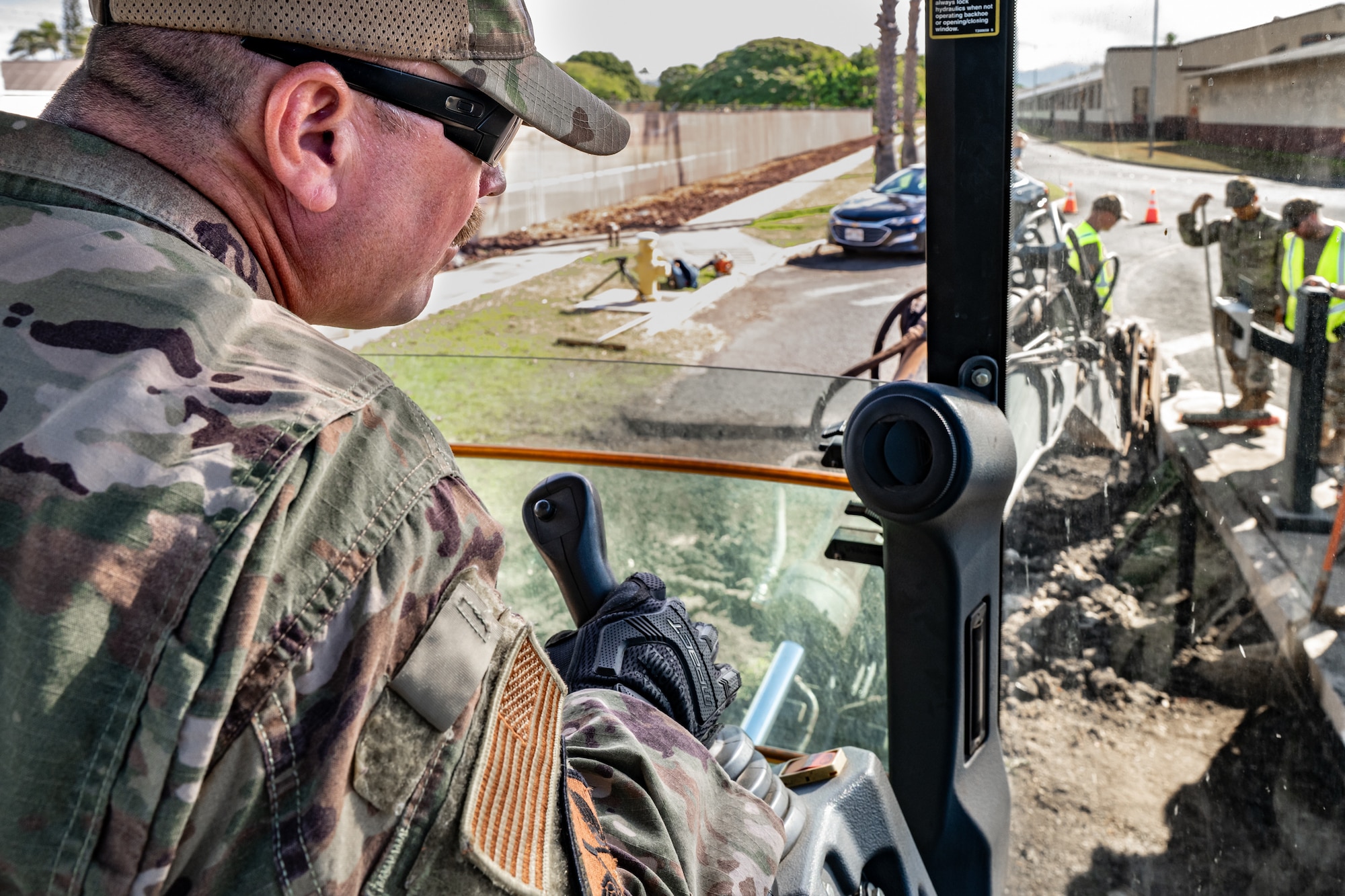 Tech. Sgt. Patrick Lawrence, a construction specialist from the Kentucky Air National Guard’s 123rd Civil Engineer Squadron, operates a backhoe to repair pavement at Joint Base Pearl Harbor-Hickam, Hawaii, with help from his active-duty counterparts at the 647th Civil Engineer Squadron on July 29, 2025. Lawrence is among more than 70 Airmen from the Louisville-based 123rd Airlift Wing to conduct annual training here over 14 days, sharpening skills that enhance their global employment as Multi-Capable Airmen. (U.S. Air National Guard photo by Dale Greer)