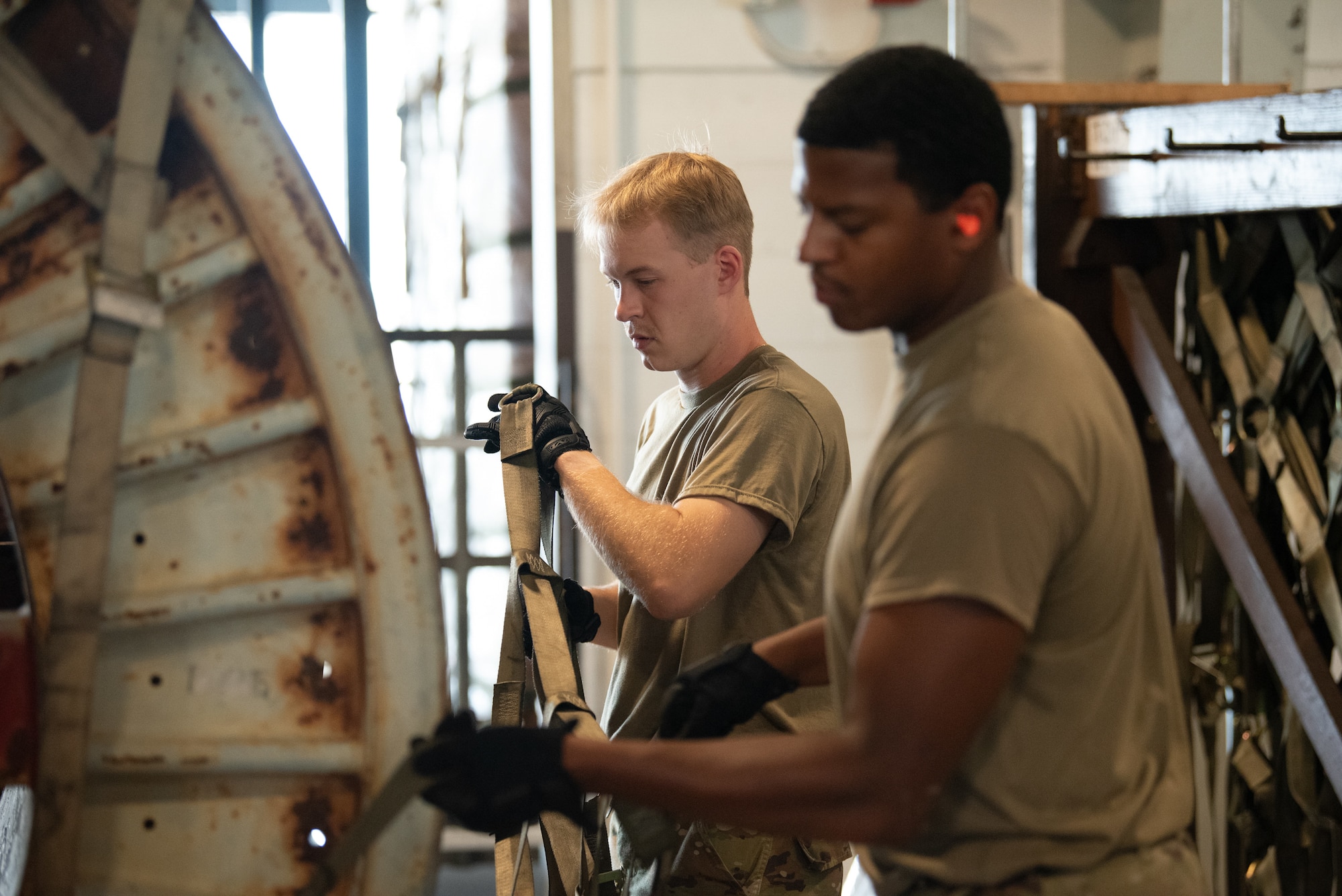 Airman First Class Cole Davidson, left, and Senior Airman Jacob Dawson, aerial porters from the Kentucky Air National Guard’s 123rd Logistics Readiness Squadron, strap down a pallet at the cargo warehouse at Joint Base Pearl Harbor-Hickam, Hawaii, on July 30, 2025. The Kentucky Guard troops were among more than 70 personnel from the Louisville-based 123rd Airlift Wing to conduct annual training here over 14 days, sharpening skills that enhance their employment as Multi-Capable Airmen. (U.S. Air National Guard photo by Phil Speck)