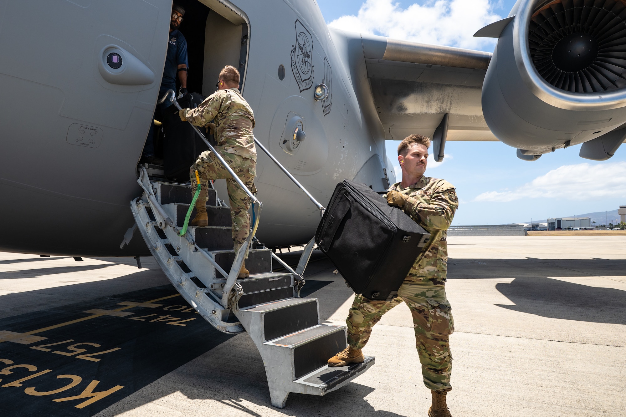 Tech. Sgt. James Ford, an aerial porter from the Kentucky Air National Guard’s 123rd Logistics Readiness Squadron, offloads passenger luggage from a U.S. Air Force C-17 Globemaster II at Joint Base Pearl Harbor-Hickam, Hawaii, on July 30, 2025. Ford was among more than 70 personnel from the Louisville-based 123rd Airlift Wing to conduct annual training here over 14 days, sharpening skills that enhance their employment as Multi-Capable Airmen. (U.S. Air National Guard photo by Dale Greer)