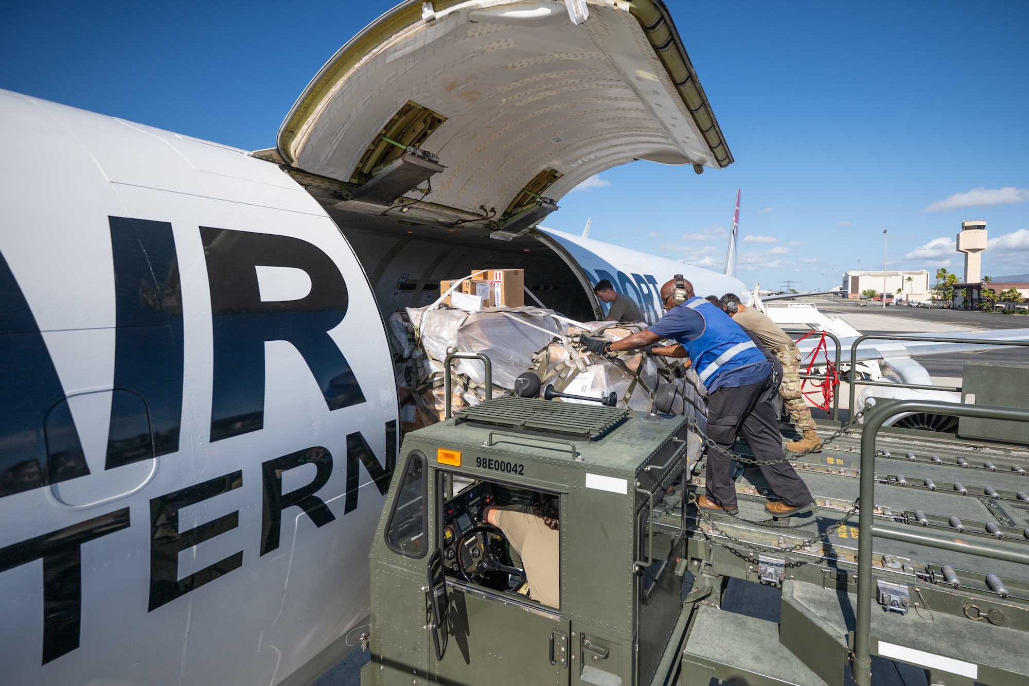 Aerial porters from the Kentucky Air National Guard’s 123rd Logistics Readiness Squadron work with their active-duty and civilian counterparts from the 735th Air Mobility Squadron to load cargo onto a Boeing 757 at Joint Base Pearl Harbor-Hickam, Hawaii, on Aug. 4, 2025. The Kentucky Guard troops were among more than 70 personnel from the Louisville-based 123rd Airlift Wing to conduct annual training here over 14 days, learning new skills that enhance their global employment as Multi-Capable Airmen. (U.S. Air National Guard photo by Dale Greer)
