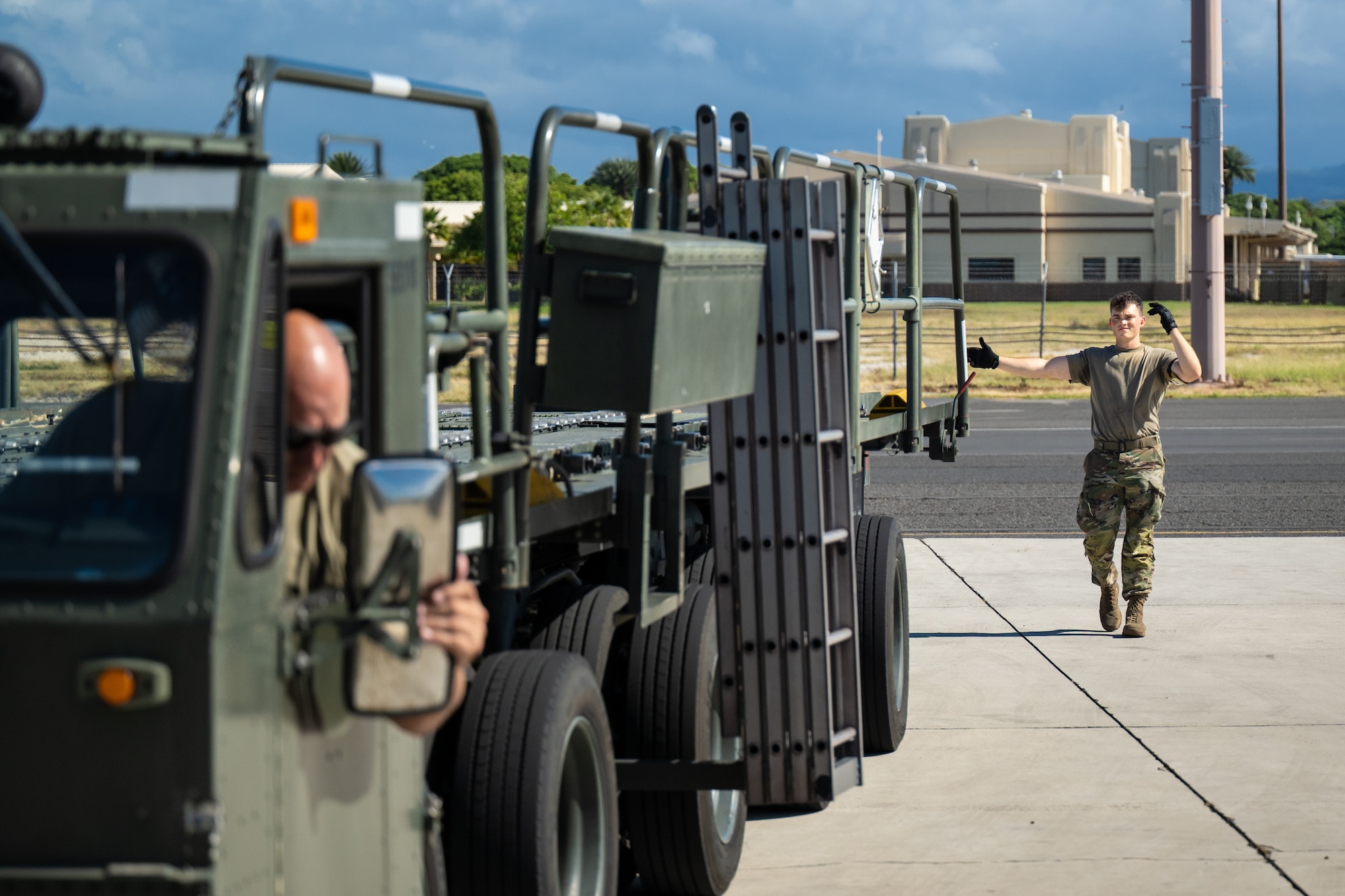 Airman 1st Class Beau Barker, an aerial porter from the Kentucky Air National Guard’s 123rd Logistics Readiness Squadron, directs a Tunner cargo loader on the flight line at Joint Base Pearl Harbor-Hickam, Hawaii, on Aug. 4, 2025. Barker was among more than 70 personnel from the Louisville-based 123rd Airlift Wing to conduct annual training here over 14 days, sharpening skills that enhance their global employment as Multi-Capable Airmen. (U.S. Air National Guard photo by Dale Greer)