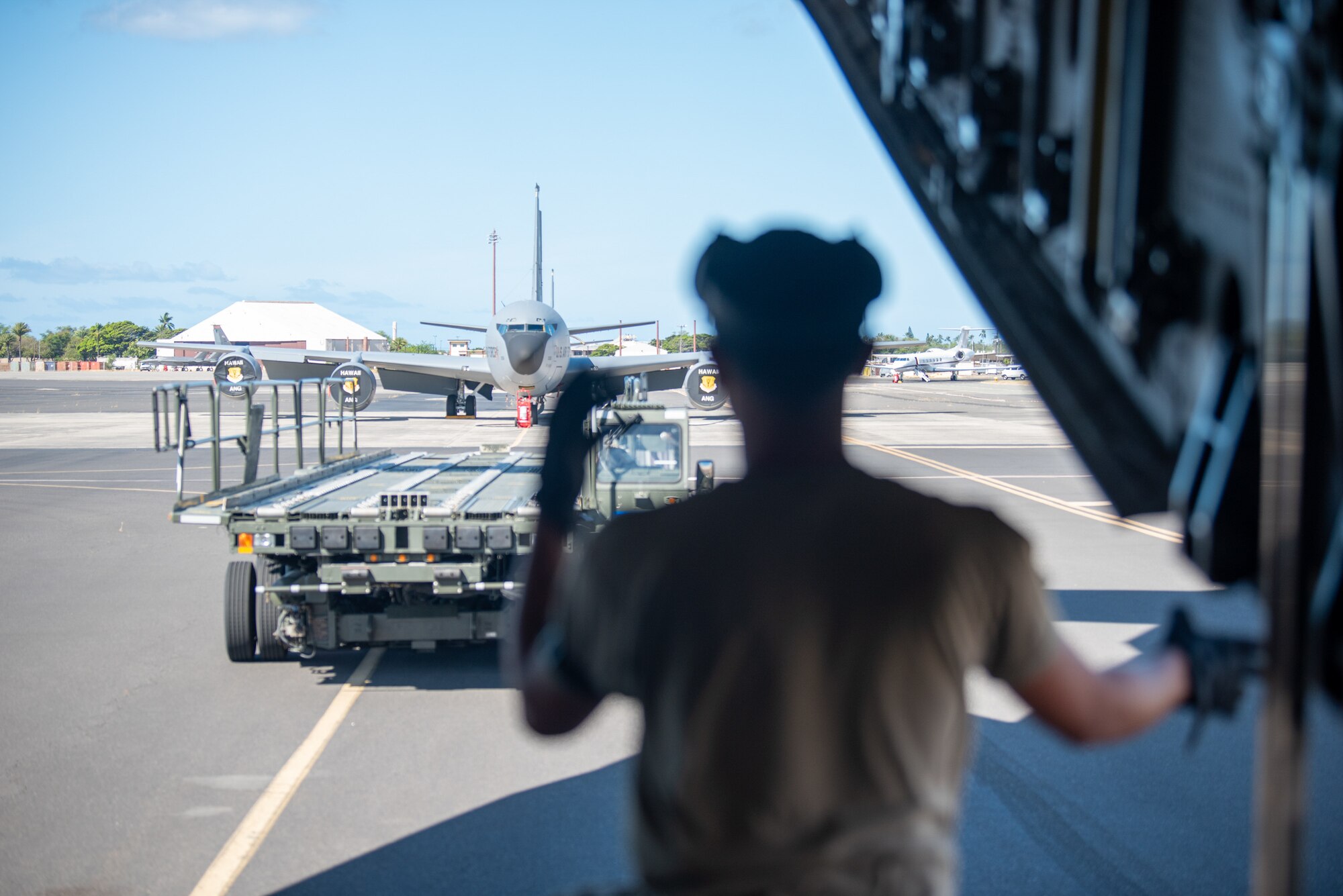 An aerial porter from the Kentucky Air National Guard’s 123rd Logistics Readiness Squadron directs a cargo loader as it approaches a C-17 Globemaster III at Joint Base Pearl Harbor-Hickam, Hawaii, on Aug. 5, 2025. Dozens of personnel from the Louisville-based unit conducted annual training here over 15 days, sharpening skills that enhance their employment as Multi-Capable Airmen. (U.S. Air National Guard photo by Phil Speck)
