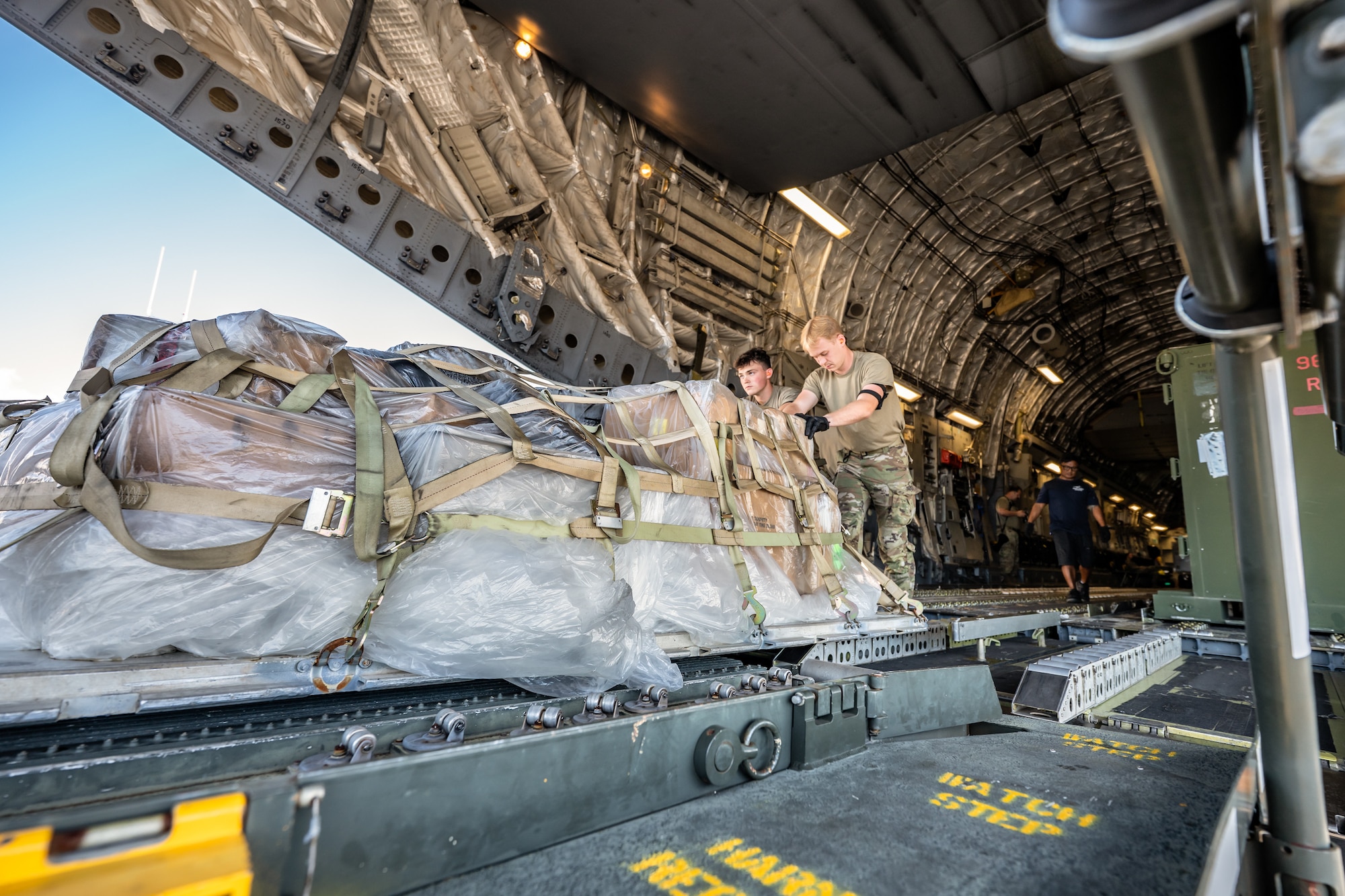 Airman 1st Class Beau Barker, left, and Airman 1st Class Cole Davidson, aerial porters from the Kentucky Air National Guard’s 123rd Logistics Readiness Squadron, push a cargo pallet off a U.S. Air Force C-17 Globemaster II aircraft at Joint Base Pearl Harbor-Hickam, Hawaii, on Aug. 5, 2025. Barker and Davidson were among more than 70 personnel from the Louisville-based 123rd Airlift Wing to conduct annual training here over 14 days, learning new skills that enhance their global employment as Multi-Capable Airmen. (U.S. Air National Guard photo by Dale Greer)