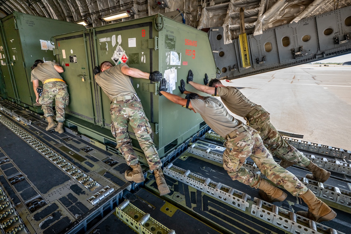 Aerial porters from the Kentucky Air National Guard’s 123rd Logistics Readiness Squadron work with their active-duty and civilian counterparts from the 735th Air Mobility Squadron to load a shipping container onto a U.S. Air Force C-17 Globemaster II at Joint Base Pearl Harbor-Hickam, Hawaii, on Aug. 5, 2025. The Kentucky Guard troops were among more than 70 personnel from the Louisville-based 123rd Airlift Wing to conduct annual training here over 14 days, learning new skills that enhance their global employment as Multi-Capable Airmen. (U.S. Air National Guard photo by Dale Greer)