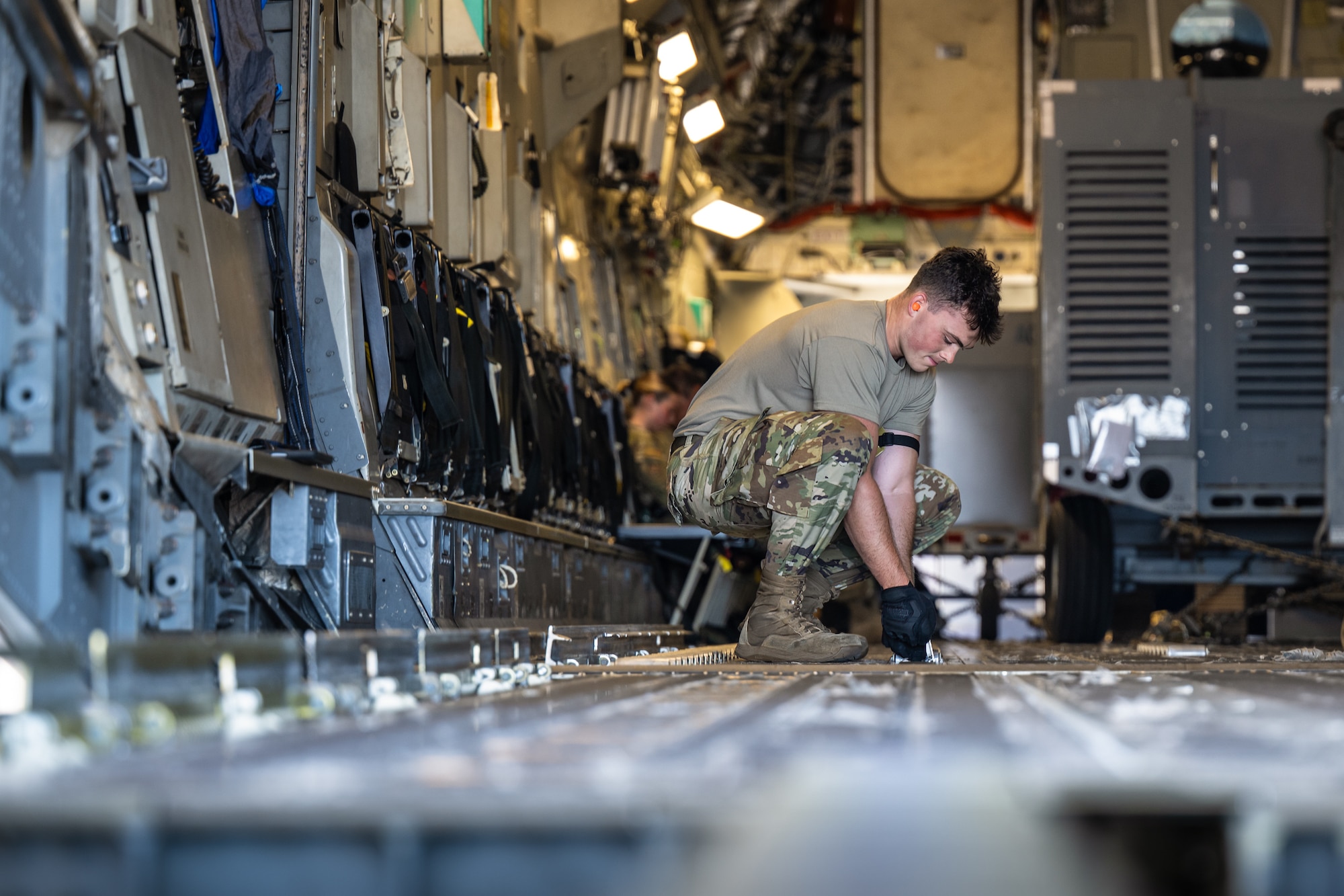 Airman 1st Class Beau Barker, an aerial porter from the Kentucky Air National Guard’s 123rd Logistics Readiness Squadron, adjusts the rollers on the floor of a U.S. Air Force C-17 Globemaster II at Joint Base Pearl Harbor-Hickam, Hawaii, on Aug. 5, 2025. Barker was among more than 70 personnel from the Louisville-based 123rd Airlift Wing to conduct annual training here over 14 days, learning new skills that enhance their global employment as Multi-Capable Airmen. (U.S. Air National Guard photo by Dale Greer)