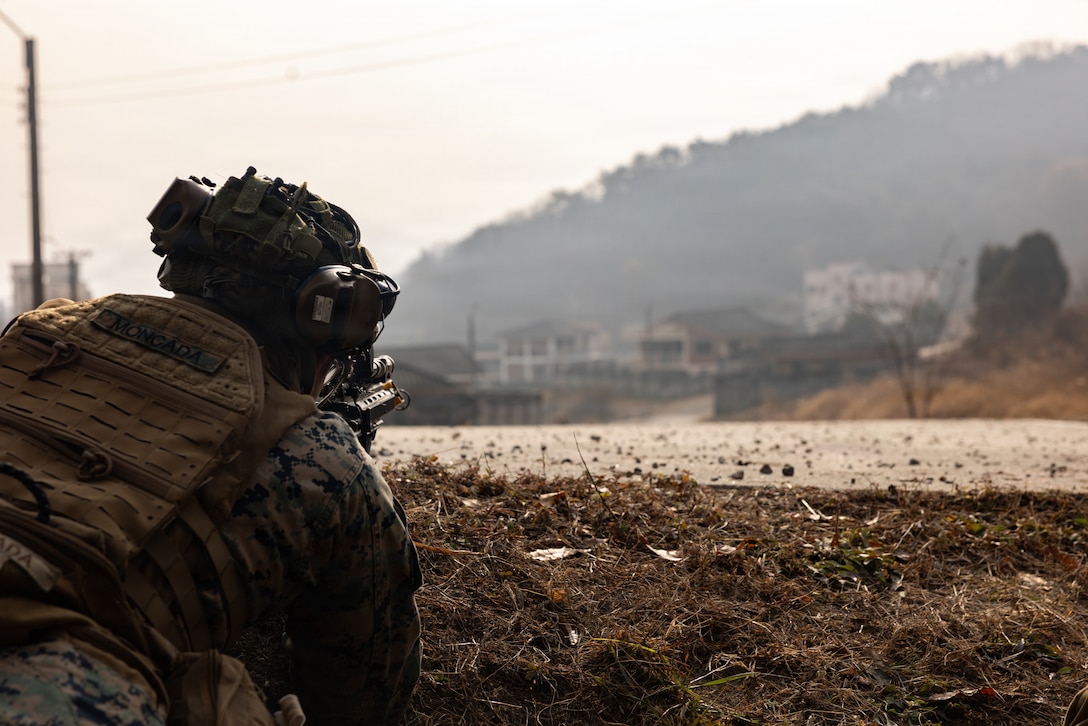 A U.S. Marine with 1st Battalion, 6th Marines, forward deployed with 4th Marine Regiment, 3rd Marine Division as part of the Unit Deployment Program, surveys his sector of fire with an M27 Infantry Automatic Rifle while conducting platoon attacks in an urban environment during Korea Viper 26.1 at Camp Rodriguez, South Korea, Dec. 17, 2025.