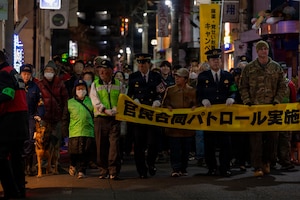 Community members drape a banner across a street