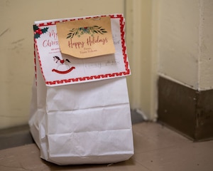 White bag with a happy holiday card written on it, sits on the corner.