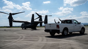 An aircraft prepares to takeoff and a truck prepares to leave