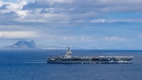 The large aircraft carrier USS Gerald R. Ford sails through the Strait of Gibraltar.