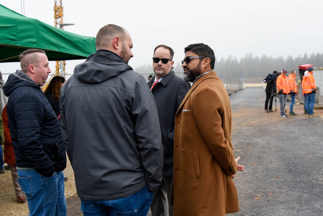 group of four men talking