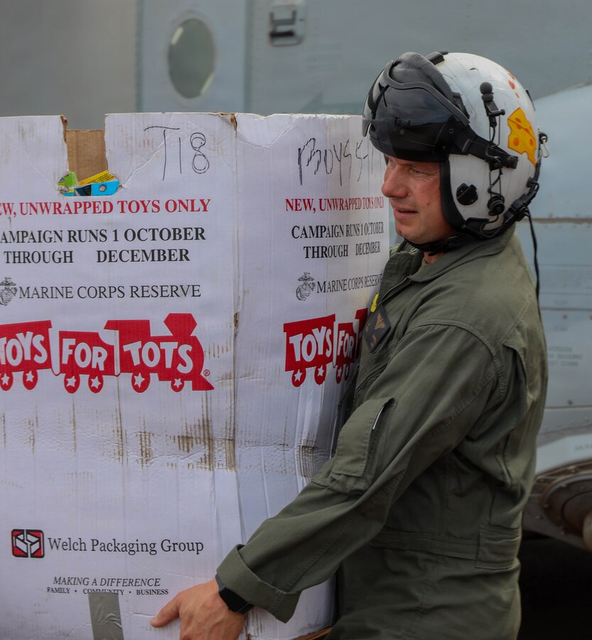 U.S. Marine Corps Lt. Col. John Campbell, commanding officer of Marine Medium Tiltrotor Squadron 268, Marine Aircraft Group 24, 1st Marine Aircraft Wing, unloads presents at Kahului Airport, Hawaii, Dec. 16, 2025. VMM‑268 transported toys and personnel to advance the Toys for Tots mission, delivering a message of joy and hope to children across Hawaii throughout the holiday season. (U.S. Marine Corps photo by Lance Cpl. Chandler Evans)