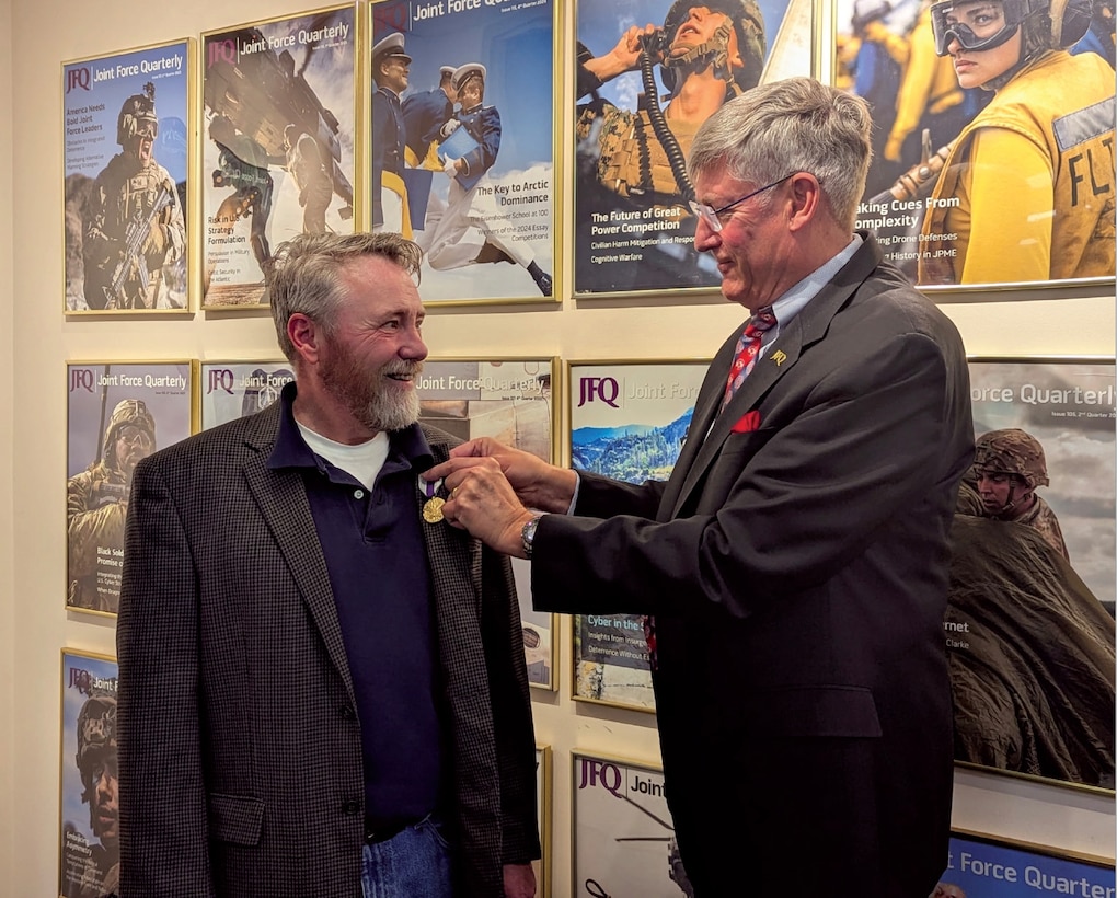 Dr. Jeffrey D. Smotherman (left) receiving the Joint Distinguished Civilian Service Award from Dr. William T. Eliason.