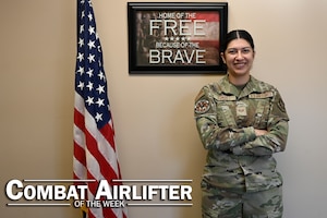 Woman poses next to a flag.