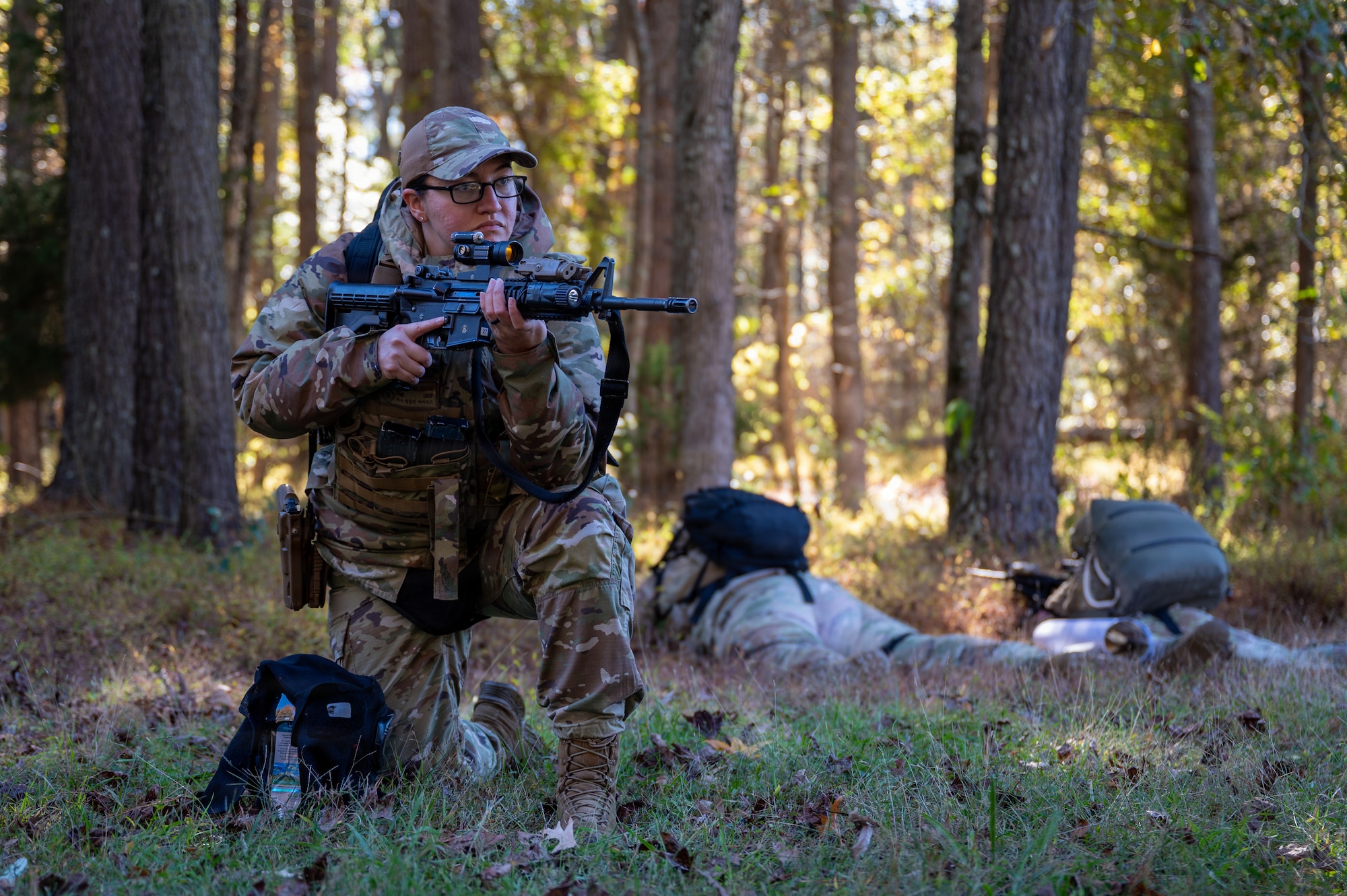 A person kneels with a rifle.