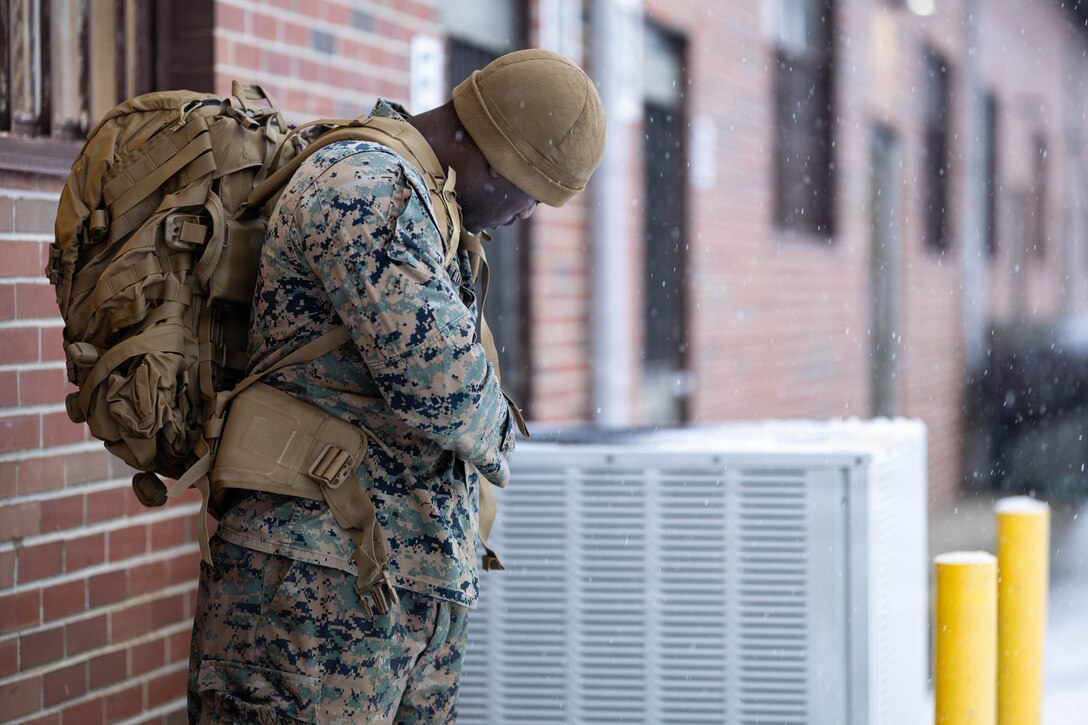 U.S. Marine Corps Cpl. Christopher Williams adjusts the straps on his main pack during a gear issue at Fort Devens, Massachusetts, Dec. 14, 2025. Williams is a rifleman with Charlie Company, 1st Battalion, 25th Marine Regiment. Marines took part in this event as an ongoing effort to prepare and maintain readiness for upcoming training and operations. (U.S. Marine Corps photo by Lance Cpl. Priscilla Flores)