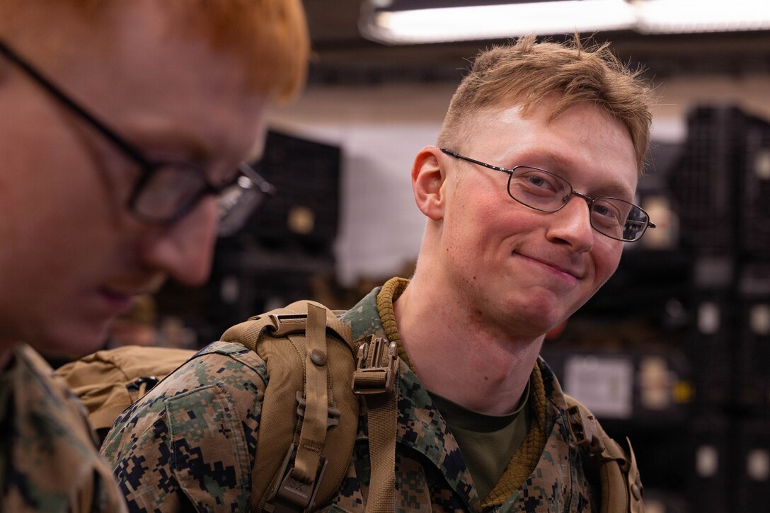 U.S. Marine Corps Lance Cpl. Kurtis Miller smiles while conversing with a fellow Marine during a gear issue at Fort Devens, Massachusetts, Dec. 14, 2025. Miller is a rifleman with Charlie Company, 1st Battalion, 25th Marine Regiment. Marines took part in this event as an ongoing effort to prepare and maintain readiness for upcoming training and operations. (U.S. Marine Corps photo by Lance Cpl. Priscilla Flores)