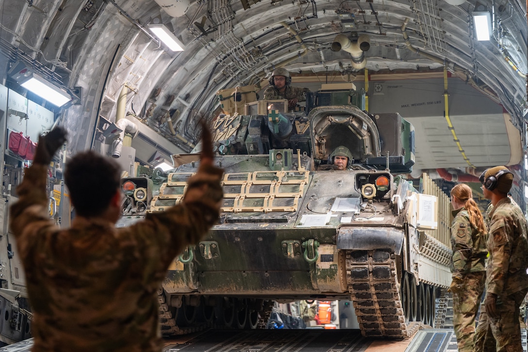 U.S. Airmen assigned to the 16th Expeditionary Airlift Squadron and U.S. Soldiers assigned to the 3rd Squadron, 278th Armored Cavalry Regiment offload an M2A3 Bradley Fighting Vehicle from a C-17 Globemaster III aircraft assigned to the 16th Expeditionary Airlift Squadron during a mission in the U.S. Central Command area of responsibility, Nov. 24, 2025. The 16th EAS directly supports the CENTCOM by moving personnel and cargo across thousands of miles in the AOR, enabling joint operations in air, land, and sea. (U.S. Air Force photo by Airman 1st Class Travis Knauss)