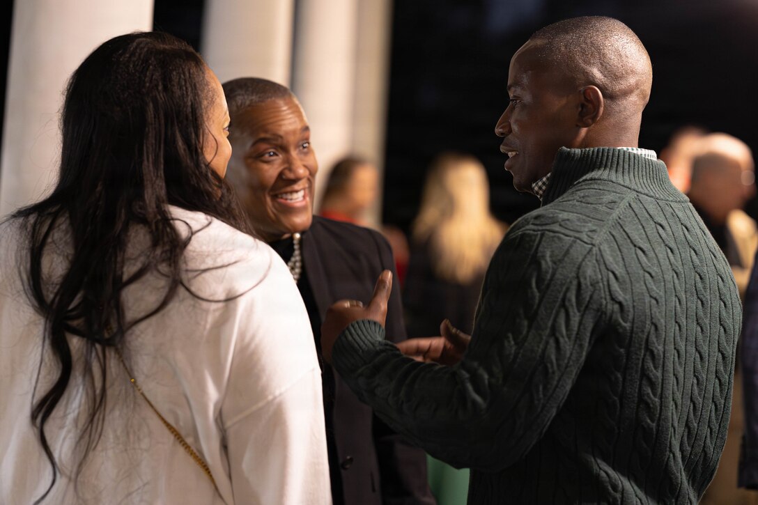 U.S. Marine Corps Sgt. Maj. Kabiru Labaran, right, command senior enlisted leader, Headquarters Battalion, Marine Forces Reserve, speaks with friends and family at the annual Christmas party held at Quarters A in New Orleans, Dec. 6, 2025. The event supported the Marine Corps Reserve Toys for Tots program, with guests contributing donations throughout the evening, and featured a concert by the Marine Forces Reserve Band as its main attraction. (U.S. Marine Corps photo by Lance Cpl. Priscilla Flores)