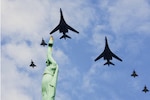 Air Force B-1B Lancer aircraft flies in formation alongside NATO Allied fighter jets over Monument of Freedom in Riga, Latvia, during Bomber Task Force Europe exercise.