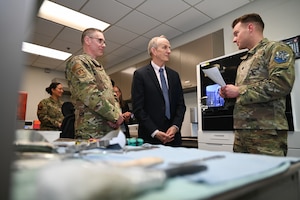Both Col. Sheets and Dr. Smith stand and listen to Lt. Col. Decker during the tour.