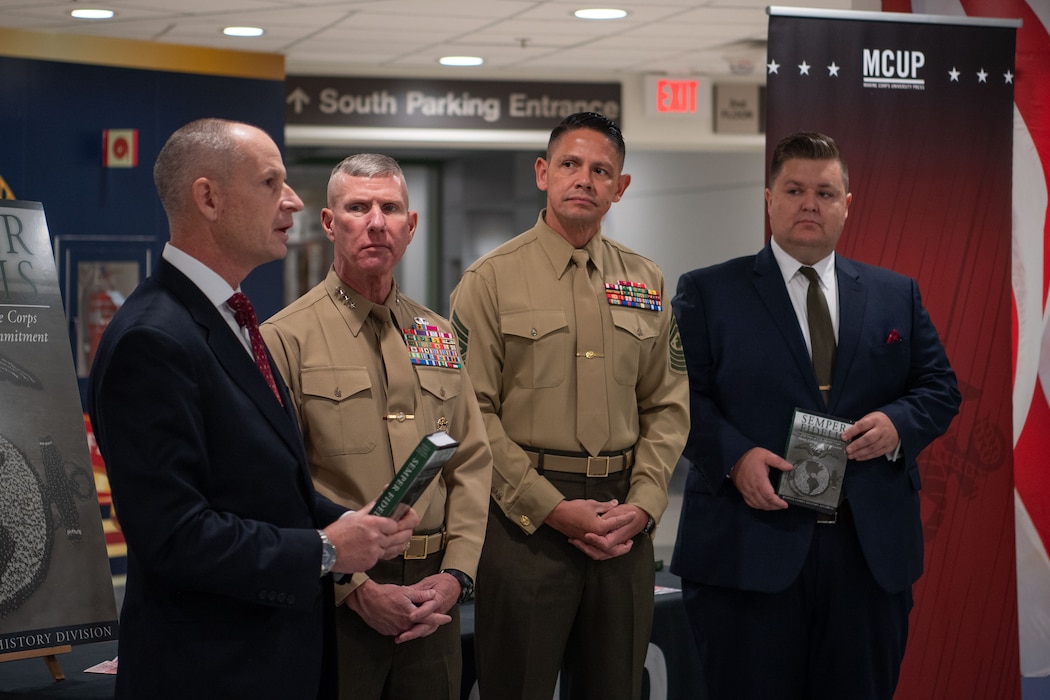 L-R:  Dr. Shawn P. Callahan (Director, Marine Corps History Division), Gen Eric M. Smith (Commandant of the Marine Corps), SgtMaj Carlos A. Ruiz (Sergeant Major of the Marine Corps), Dr. Seth A. Givens (Chief Historian, Marine Corps History Division) present a book at a Pentagon book signing ceremony on 3 Dec 2025. The ceremony honored 250 years of US Marine Corps honor, courage, and commitment. The book was written by Marine Corps History Division and published by Marine Corps University Press. (Photo by LCpl Matthew McDonnell)